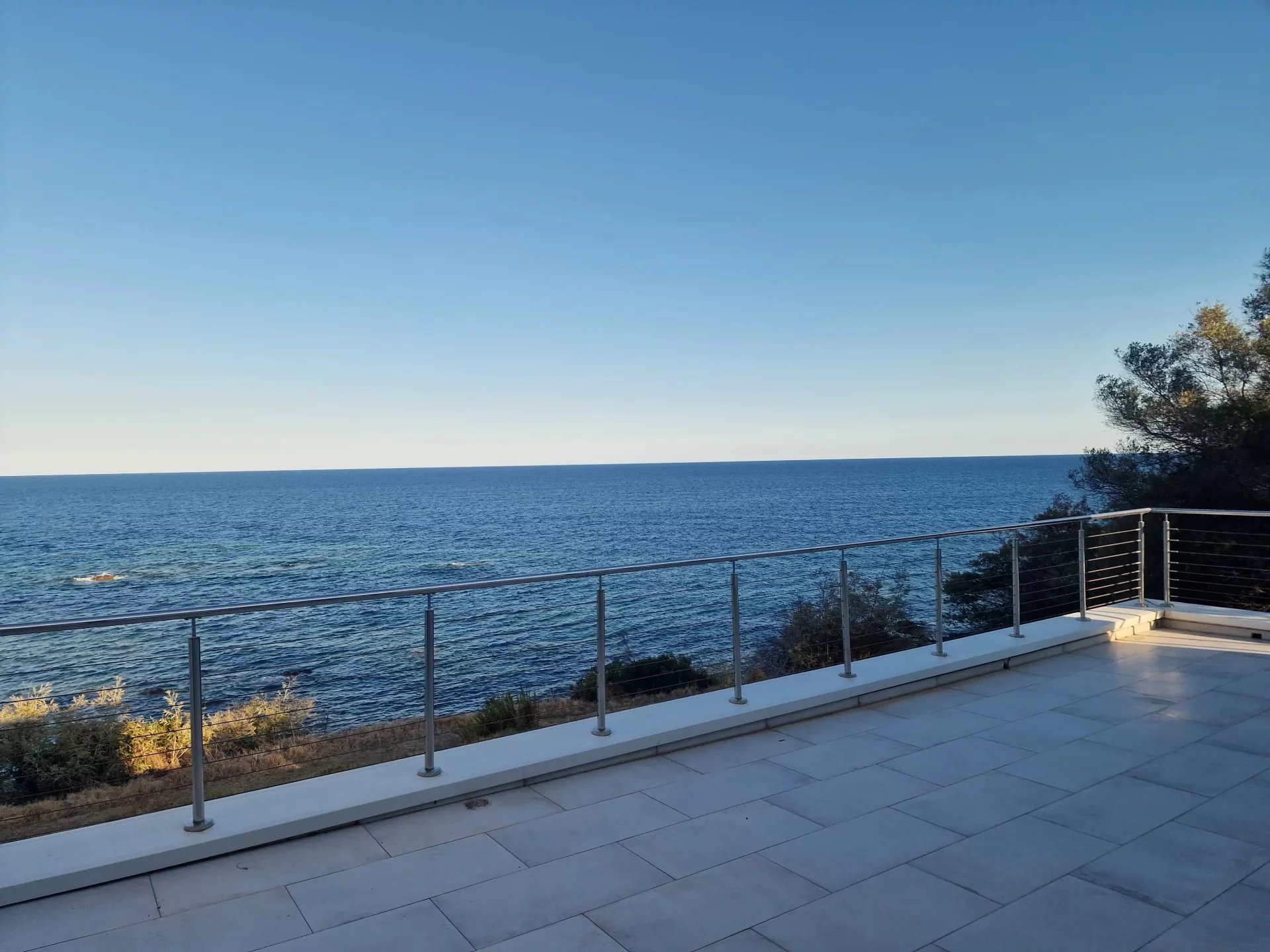 Terrasse avec vue mer à Sari-Solenzara Vue sur la mer depuis une terrasse de villa contemporaine à Sari-Solenzara, Corse.