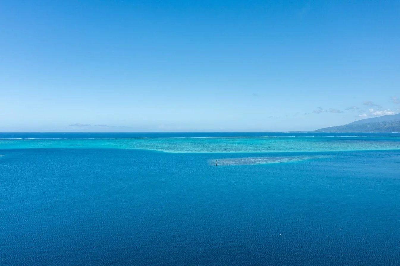 Vue sur l’océan à Toahotu, Tahiti Vue panoramique sur l'océan et le lagon à Toahotu, Tahiti, avec des nuances de bleu.