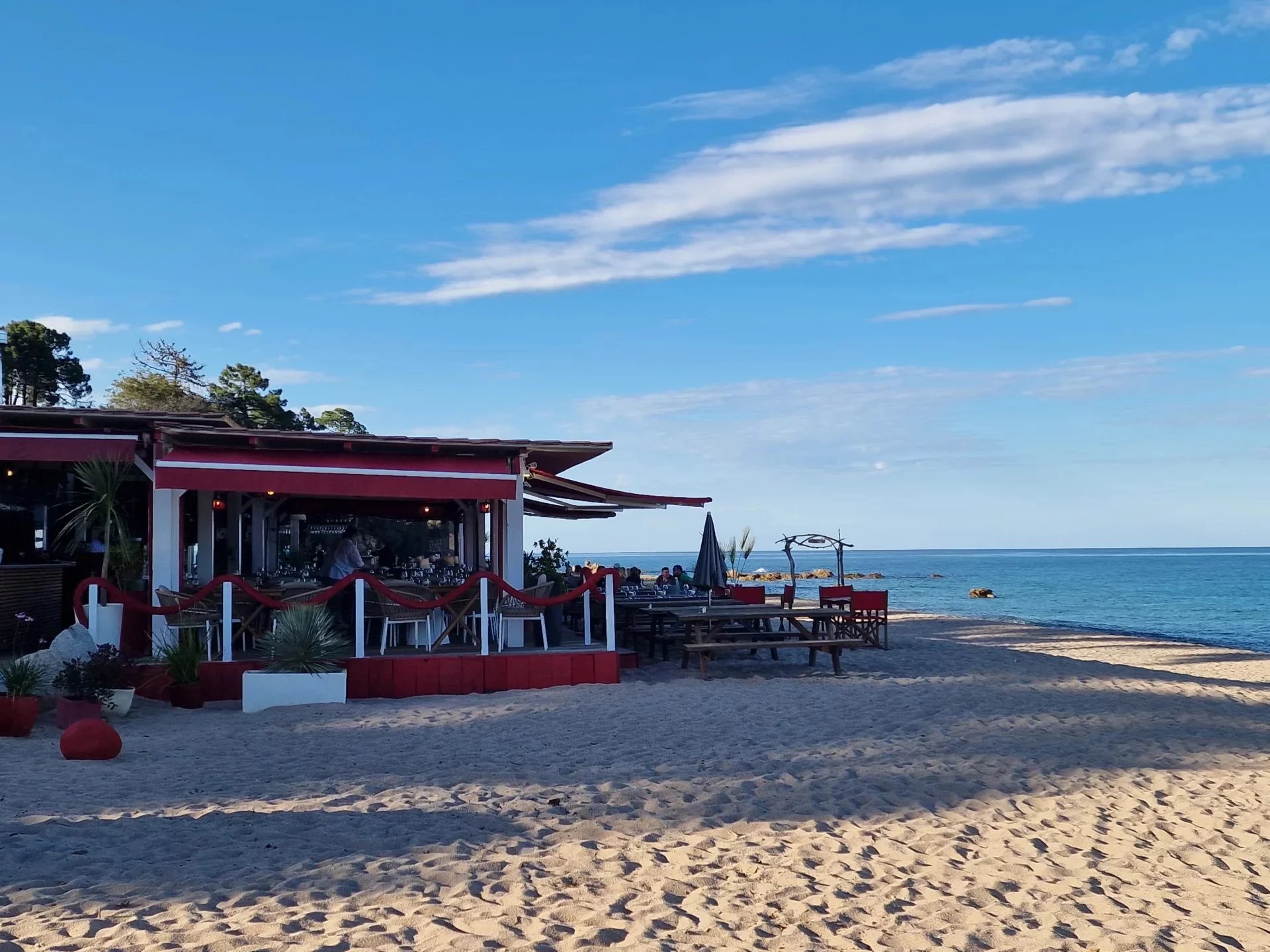 Plage à Marine de Solaro Plage avec restaurant et chaises sur le sable à Marine de Solaro, Corse.