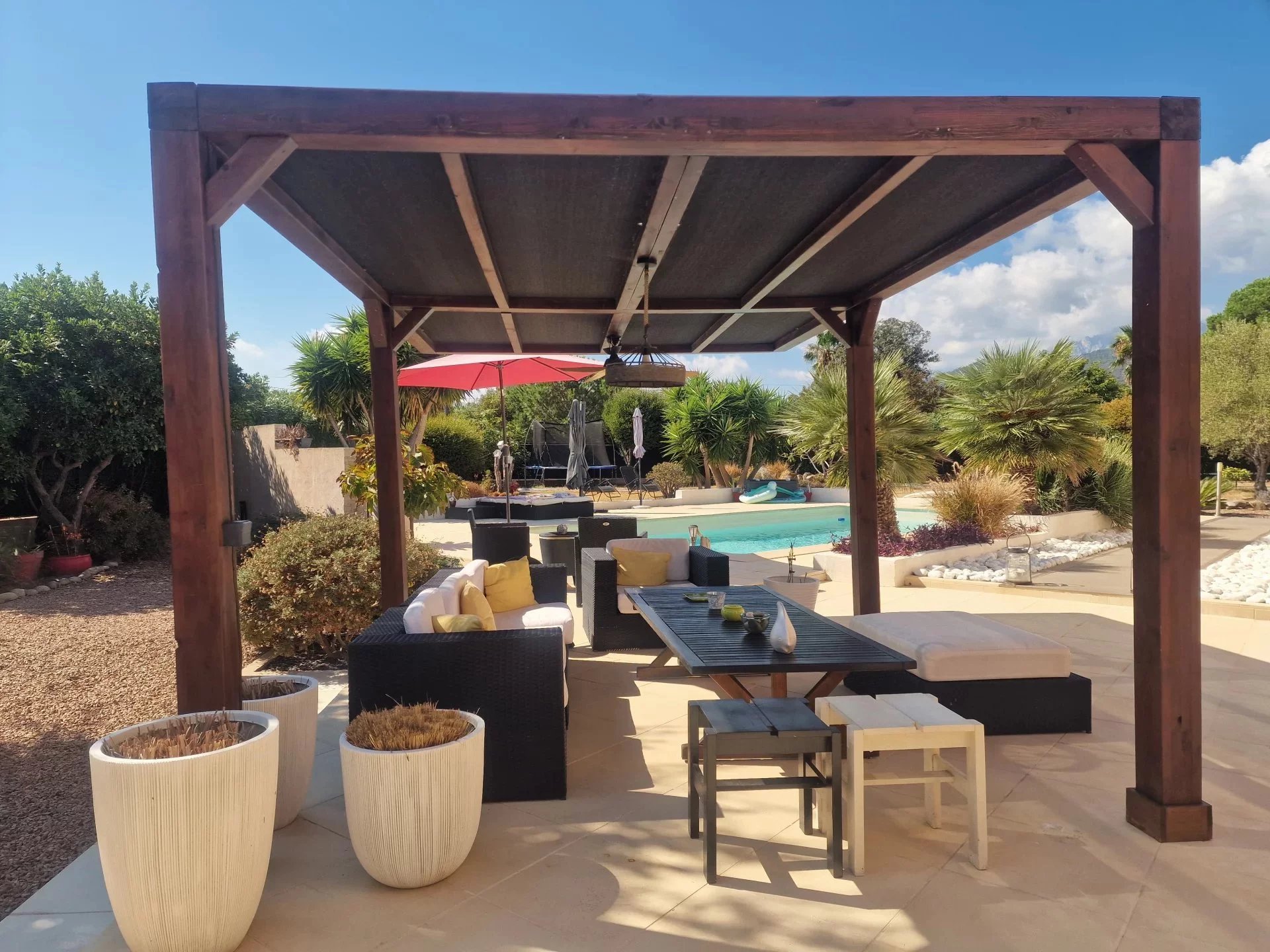 Terrasse de villa avec piscine en Corse Terrasse avec salon de jardin et piscine à la Marine de Solaro, Corse.