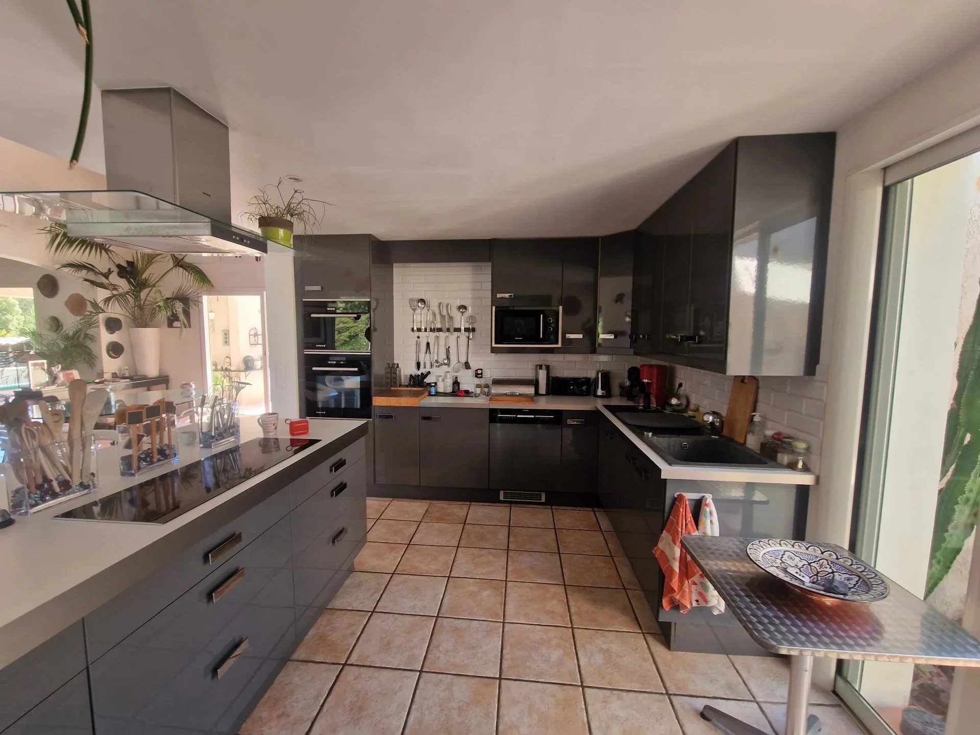 Cuisine de la villa à Solaro Cuisine moderne d'une villa à la Marine de Solaro, Corse, avec meubles gris et carrelage clair.