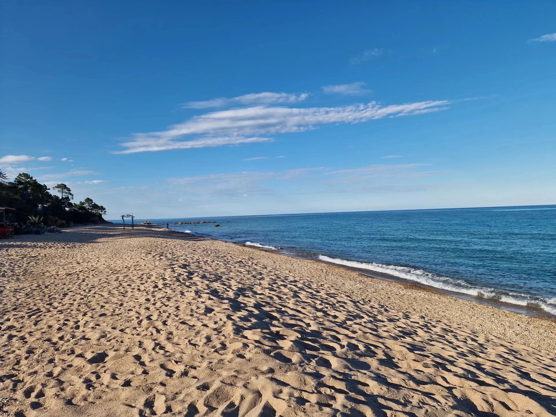 Plage à Marine de Solaro, Corse Plage de sable fin à Marine de Solaro, Corse, avec mer calme et ciel dégagé.