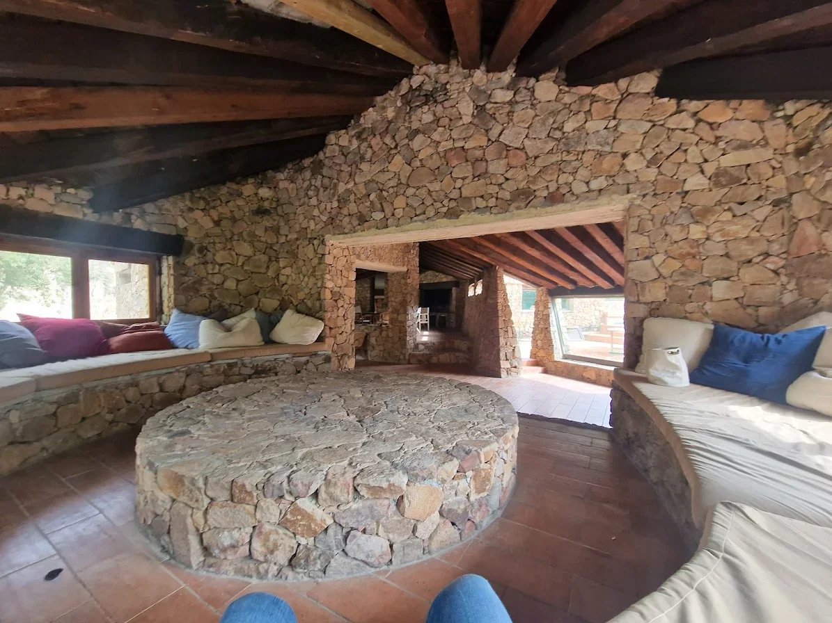 Intérieur d’une bastide en pierre à Sari-Solenzara Intérieur d'une bastide en pierre avec un salon spacieux et des murs en pierre apparente.