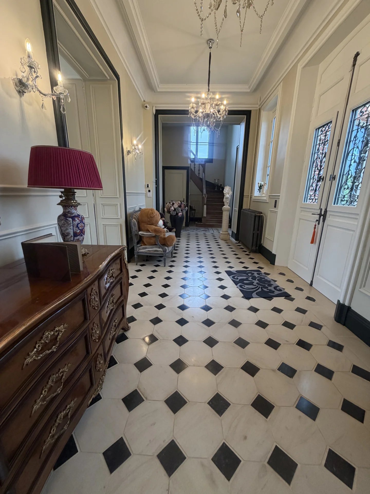 Hall d’entrée du château Intérieur d'un château avec un hall d'entrée en marbre et des meubles anciens.