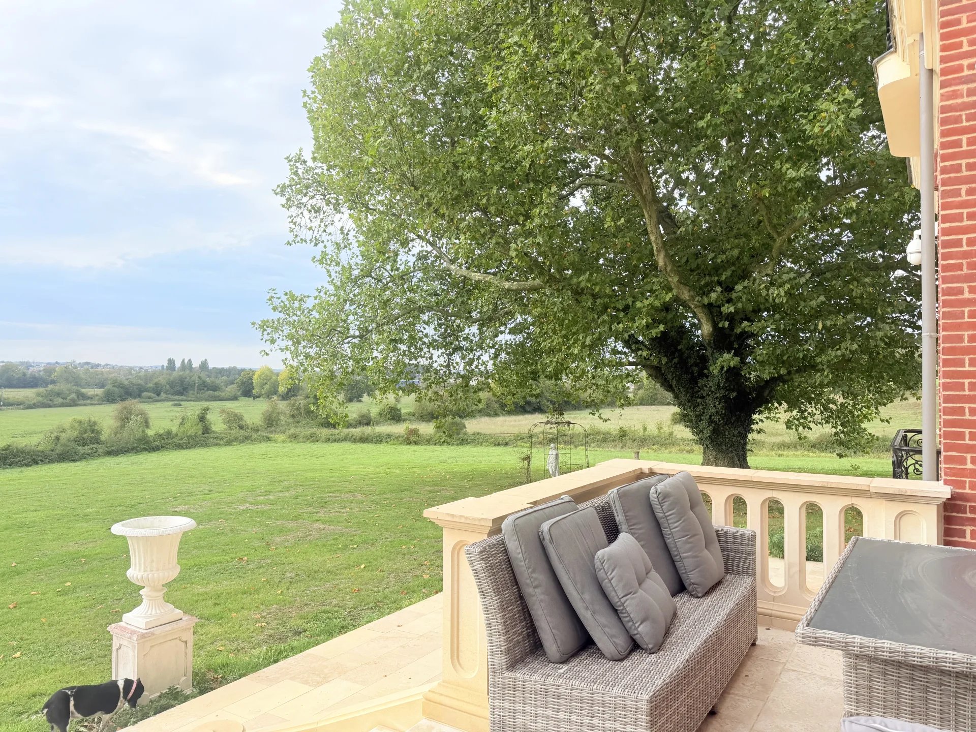 Terrasse du château équestre Terrasse d'un château avec vue sur un vaste terrain verdoyant près de Pont-l'Évêque.