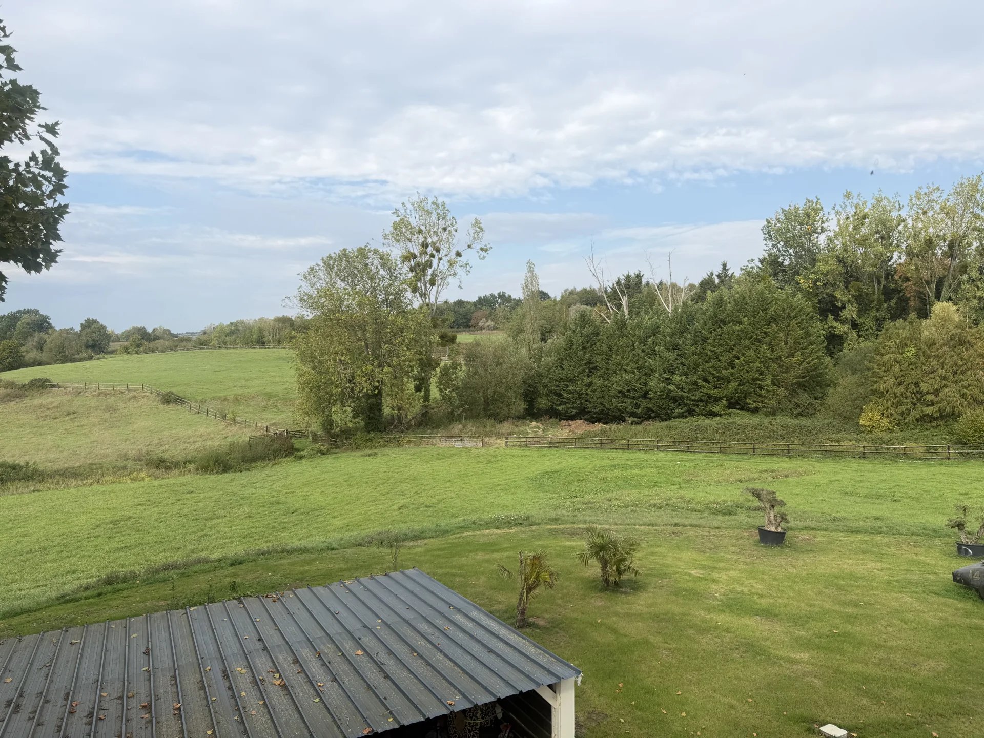 Paysage près de Pont-l’Évêque Vue dégagée sur un paysage verdoyant près de Pont-l'Évêque, avec des arbres et des prairies.