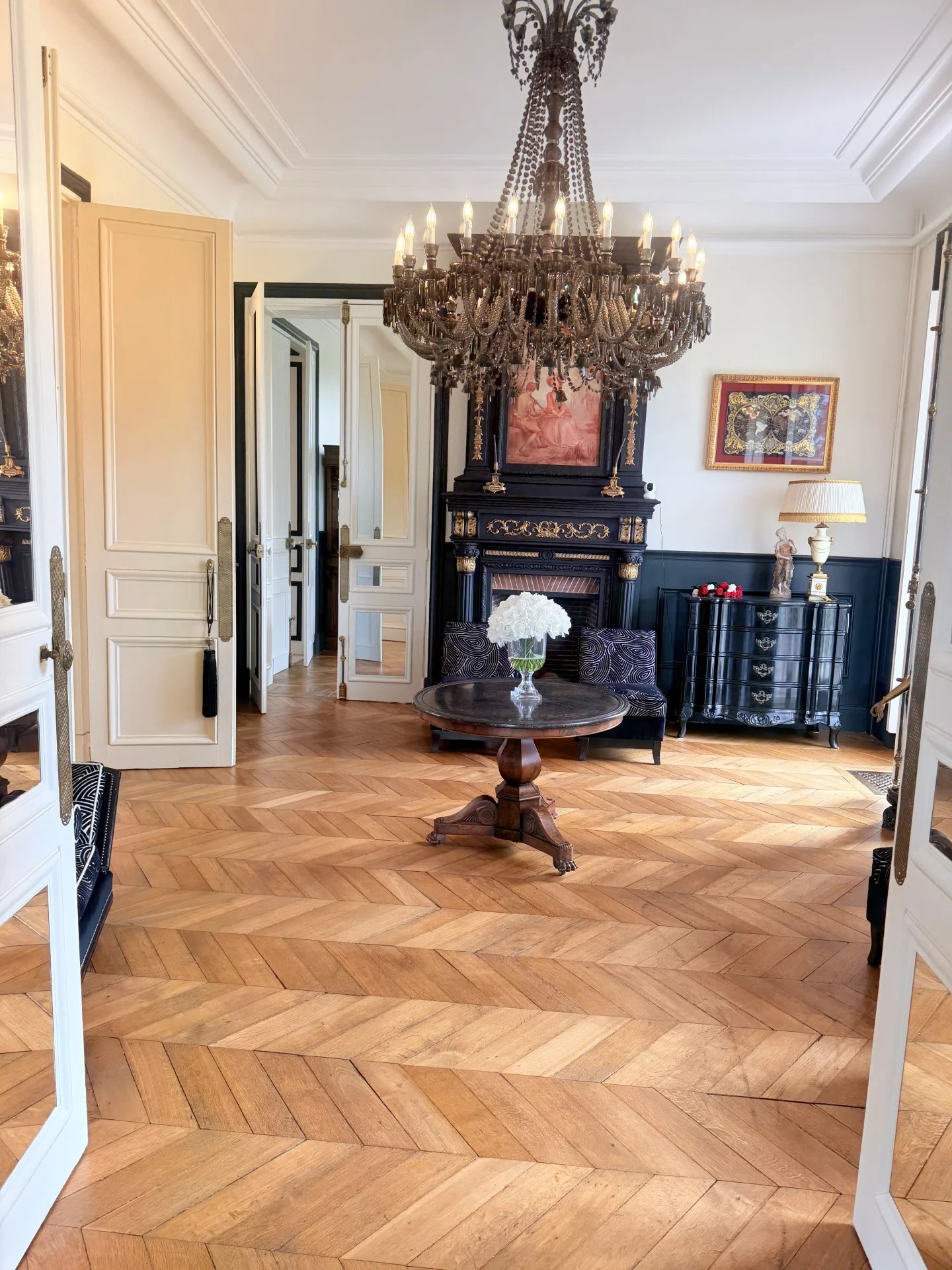 Intérieur du château équestre près de Deauville Intérieur d'un château avec un lustre, un parquet en chevrons et des meubles élégants.