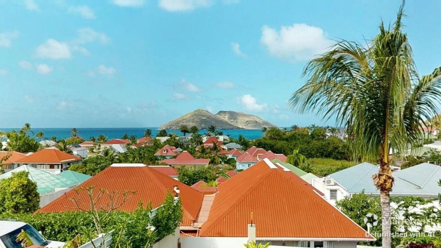 A tropical coastal neighborhood with orange tiled roofs and palm trees overlooking the sea and distant islands Propriétés clovis