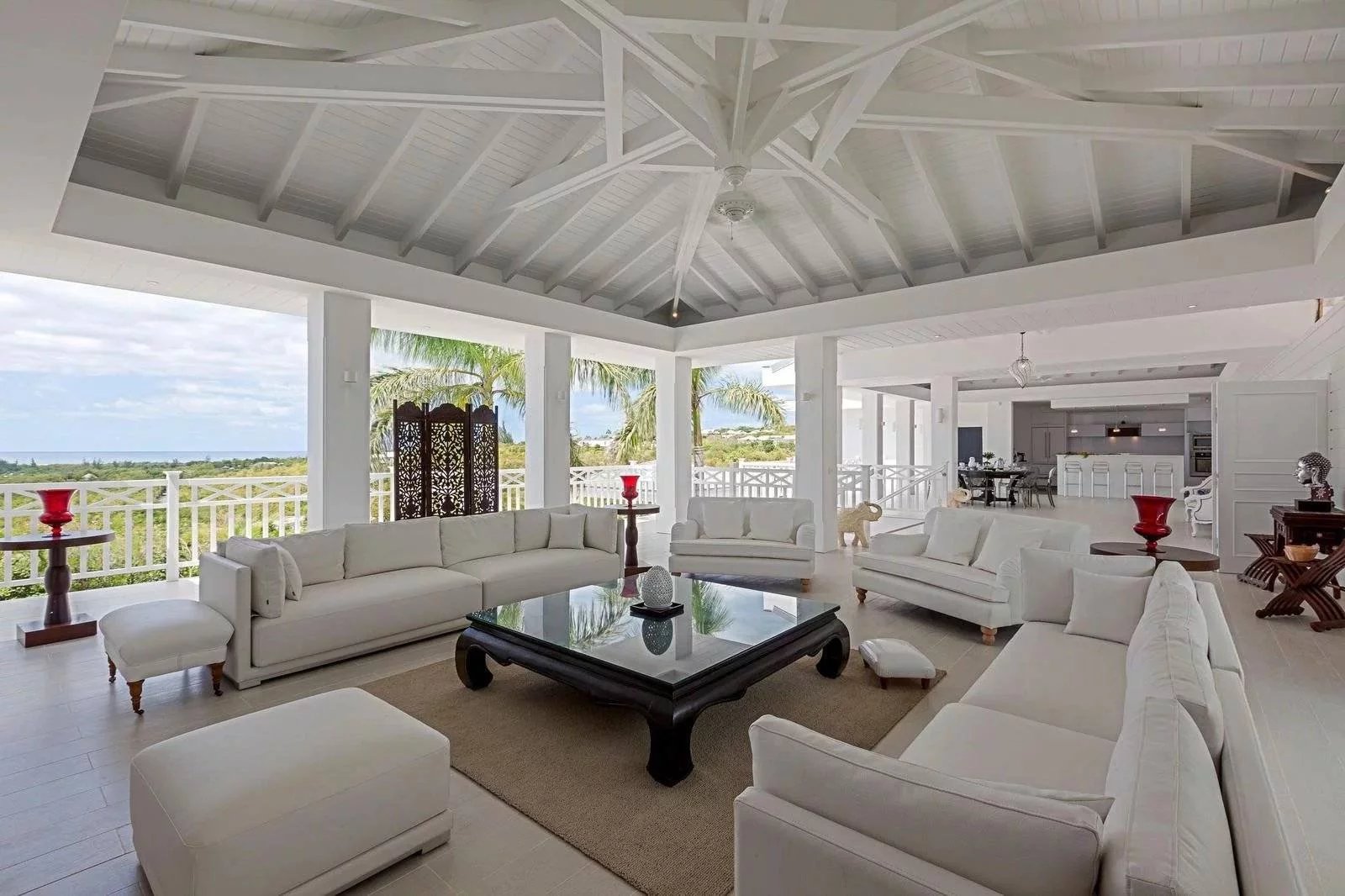 e5b55bae31c3af3e300ac7ab8fba3632_55d36e3e4d_1600-original Bright white coastal living room with multiple white sofas around a glass coffee table and ocean view outside